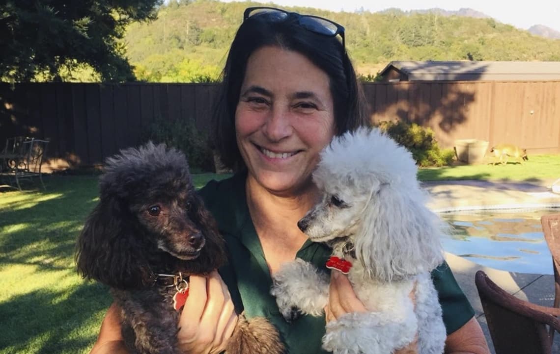 Heidi, owner of KOVA Sonoma, with two dogs by the water