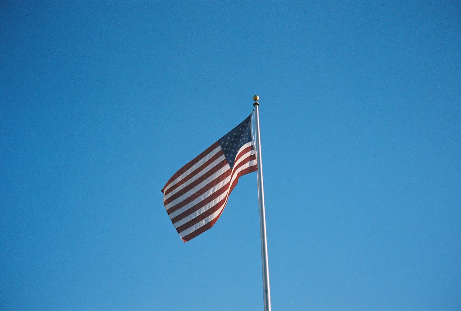 An American flag waving against a blue sky